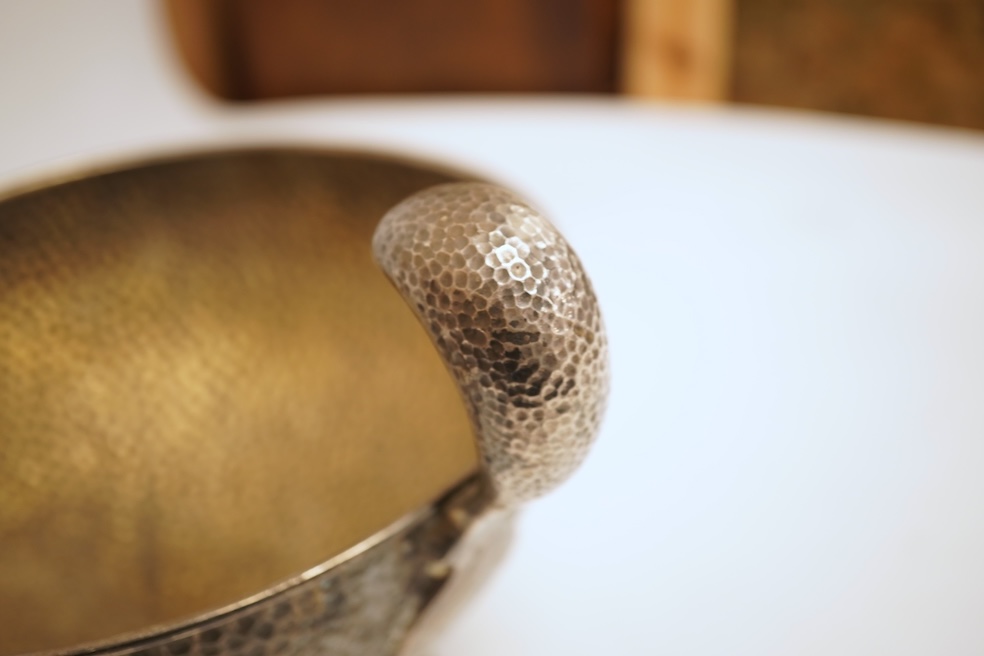 A hammered white metal two handled pedestal bowl, stamped 'Kennedy 925, diameter 18.9cm, 18.1oz.